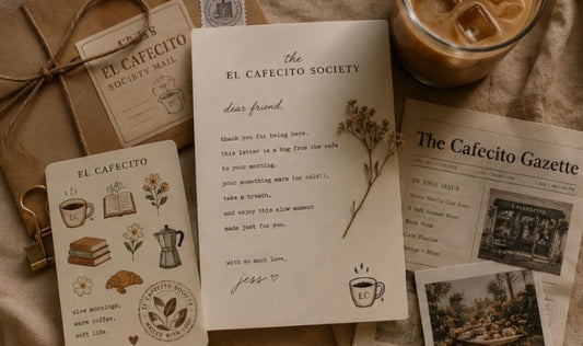 El Cafecito Ritual Letter monthly subscription — flatlay of founder letter, mini newspaper, stickers and paper goods